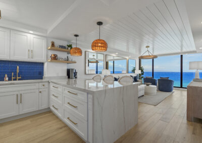 Post-remodel: bright and light modern kitchen with white cabinets, gold hardware, and blue tile backsplash