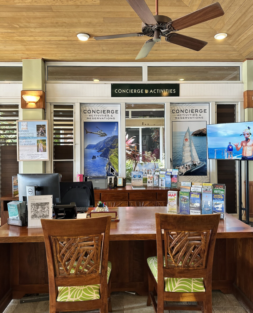Concierge and activity planning desk at property with wooden chairs