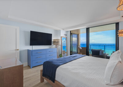 After remodel image of bedroom: kingsized bed with ocean view siding door to patio