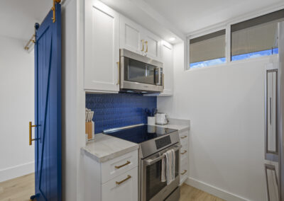 Post-remodel: brigth and light modern kitchen with white cabinets, stainless appliances, and blue tile backsplash