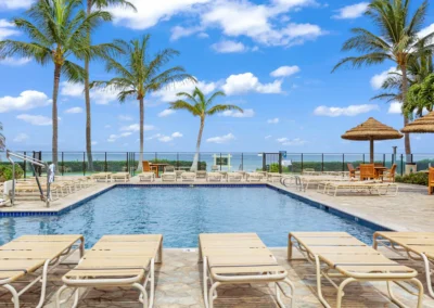 The Aston Mahana poolside view of sunchairs and bright blue pool water overlooking ocean